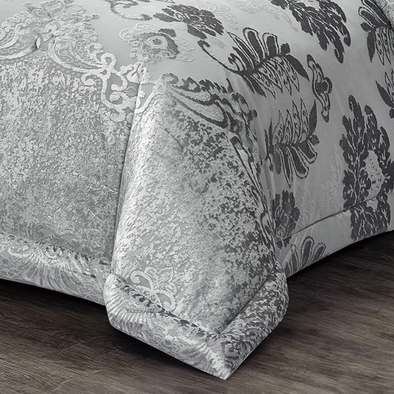 Full view of silver floral damask comforter set arranged with coordinated shams and accent cushions