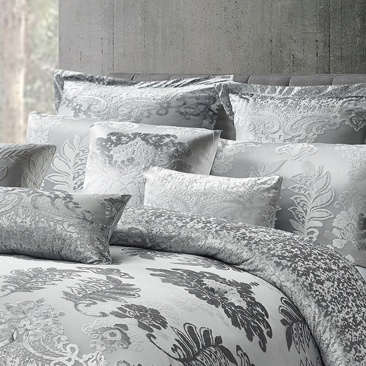 Close-up of metallic silver fabric showcasing the detailed ornate damask print and quilted edge
