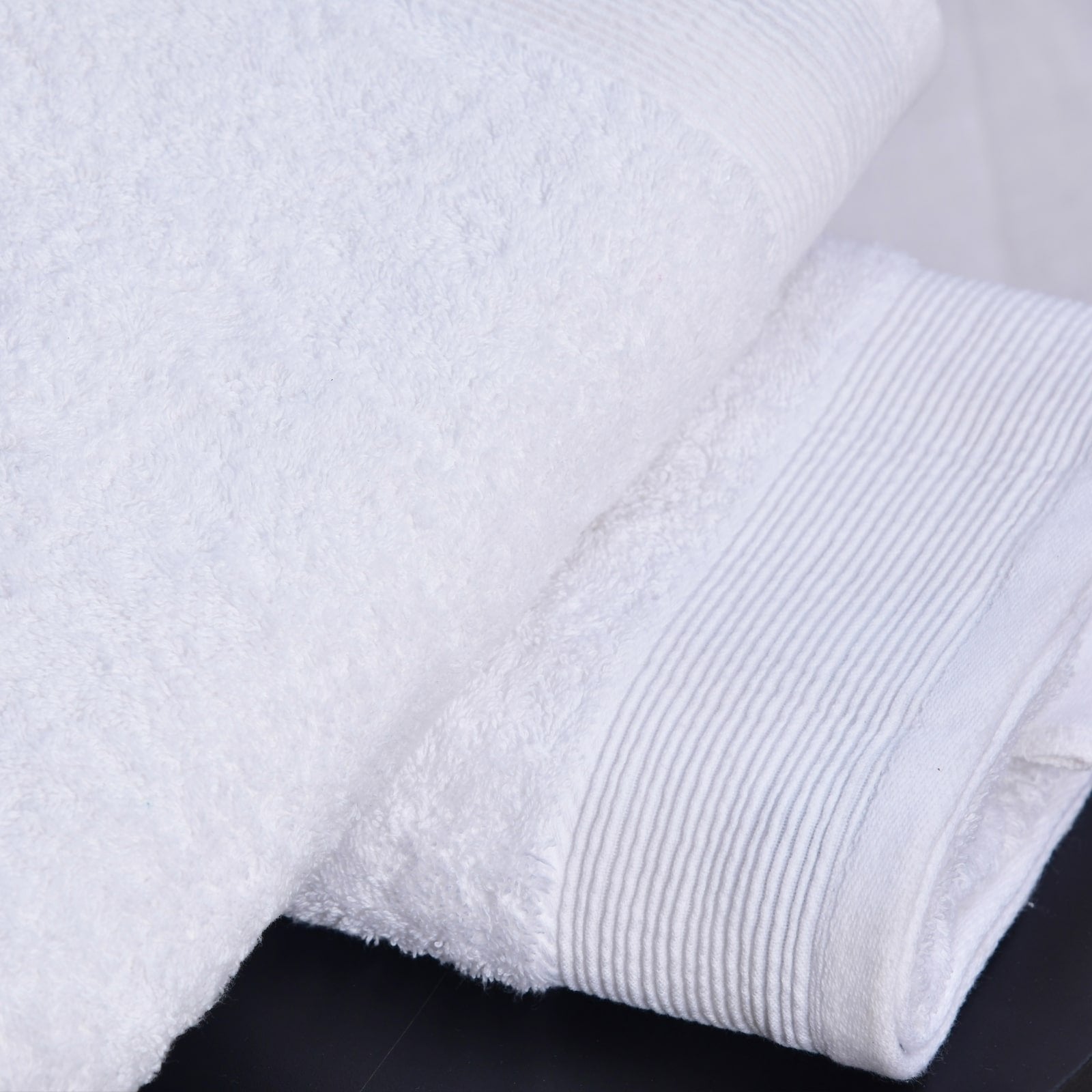 Folded white towels on white surface