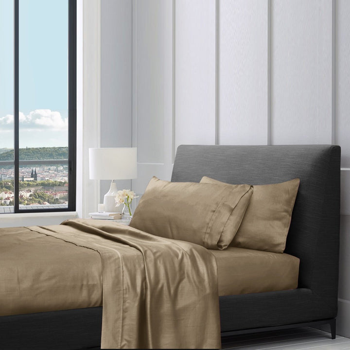 Sandrift cotton sheet set styled on a bed with pillows in a modern bedroom