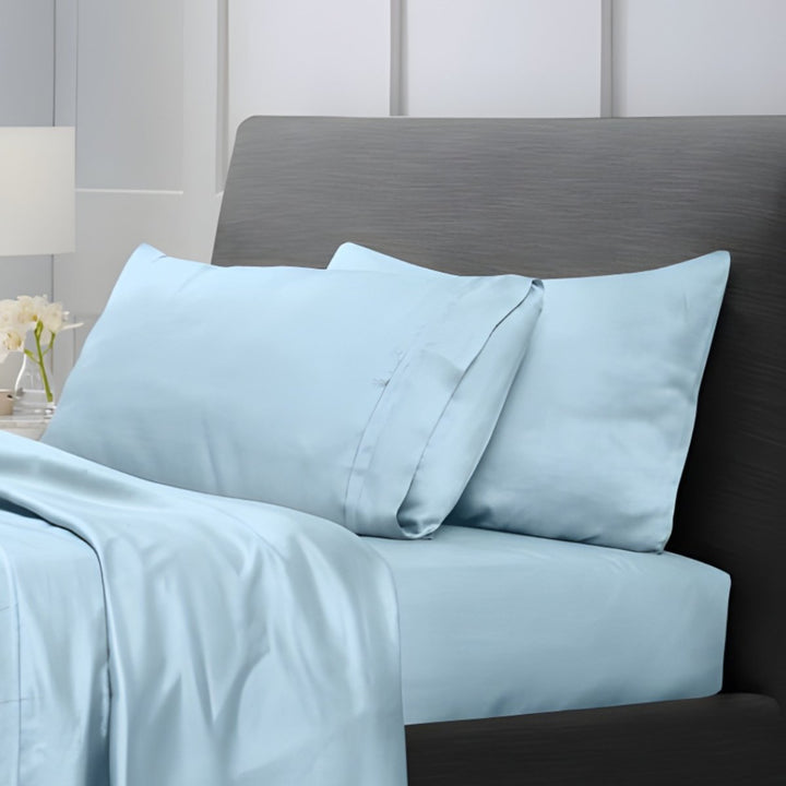 Overhead view of light blue cotton sheet set with folded top sheet and pillowcases