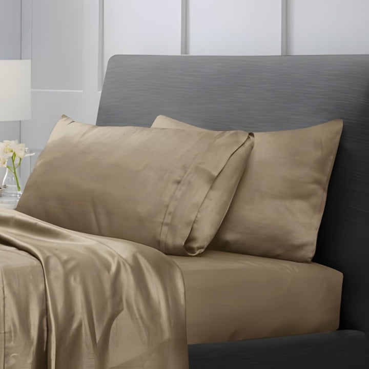 Overhead view of tan cotton sheet set with folded top sheet and pillowcases