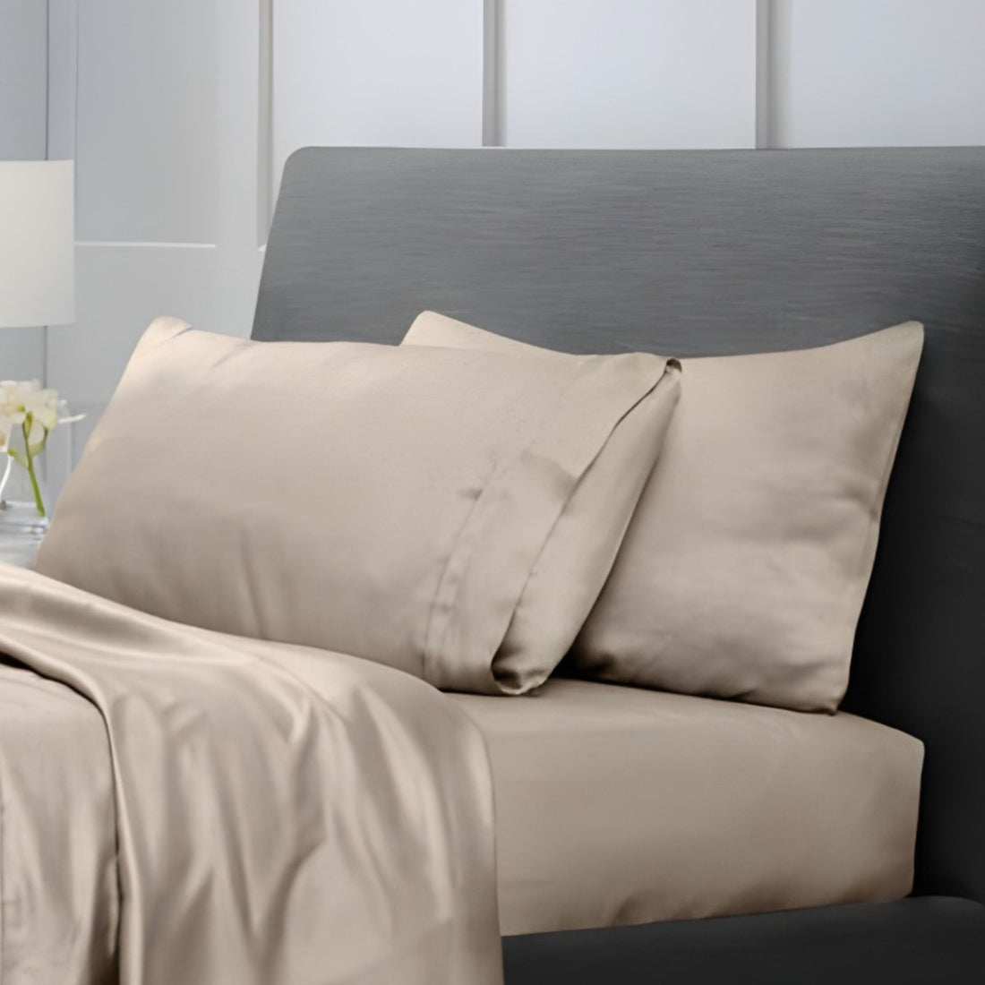 Taupe bed sheets styled on a bed with matching pillowcases in a modern bedroom