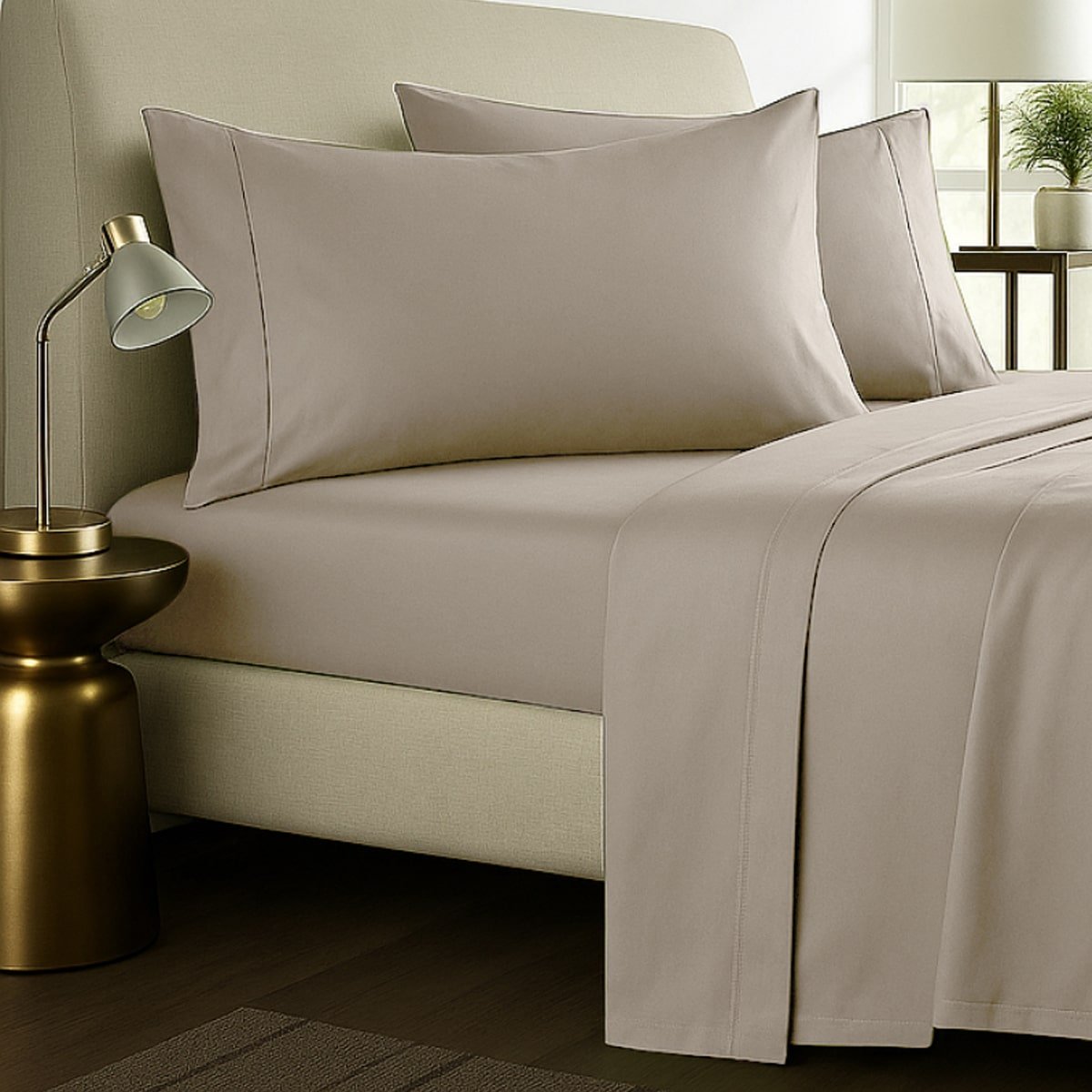 Beige bed sheets styled with pillows on a bed against wooden headboard