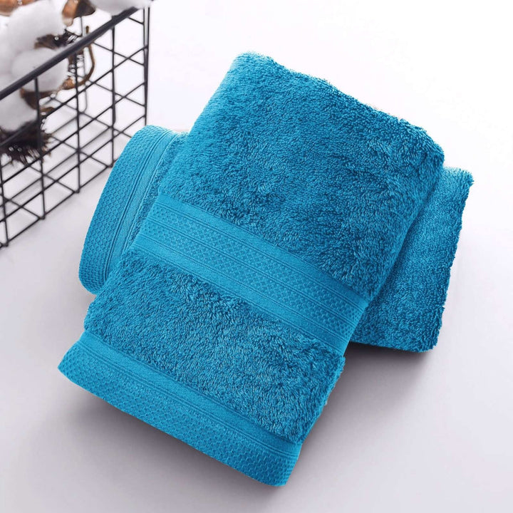 Folded teal towels on white surface