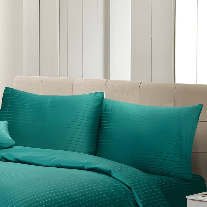 Full view of a teal striped duvet cover set with matching pillows in a modern bedroom setting