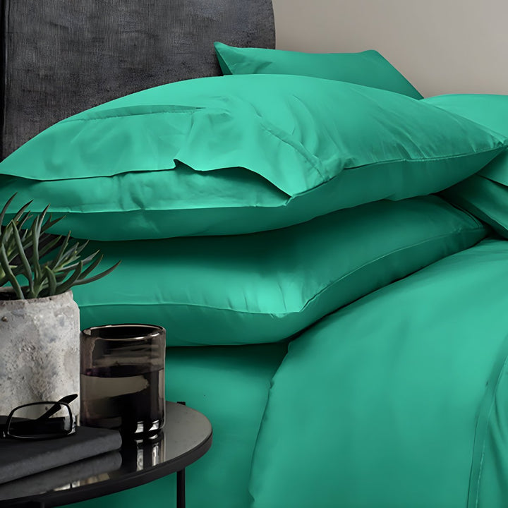 Folded teal green sheets stacked neatly