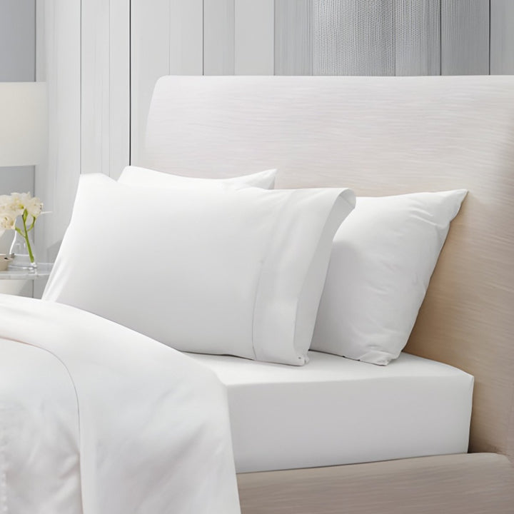 Overhead view of white cotton sheet set with folded top sheet and pillowcases